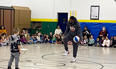  Harlem Wizard player play ball with student